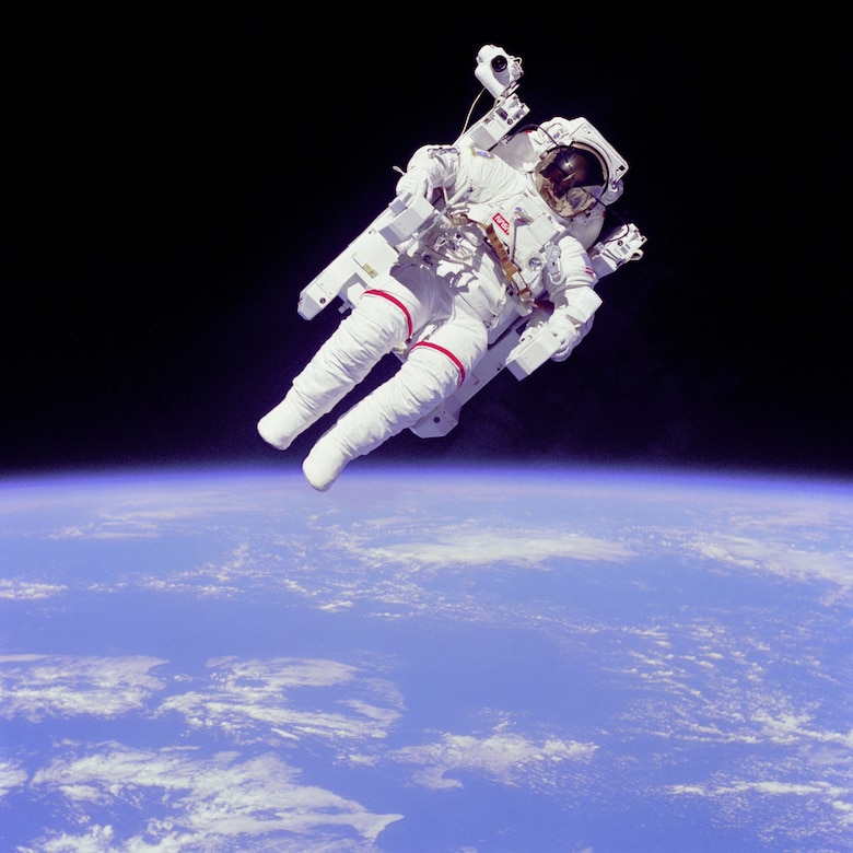 An astronaut in a spacesuit floats untethered above Earth.