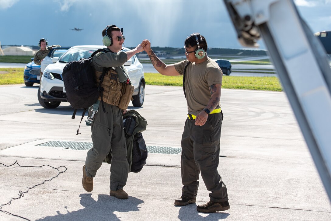 U.S. Air Force Capt. Daniel Petroshev, 37th Expeditionary Bomb Squadron pilot, left, greets Senior Airman Calvin Agabin, 28th Aircraft Maintenance Squadron crew chief, both assigned to Ellsworth Air Force Base, South Dakota, prior to boarding a B-1B Lancer at Andersen AFB, Guam, Nov. 2, 2022.