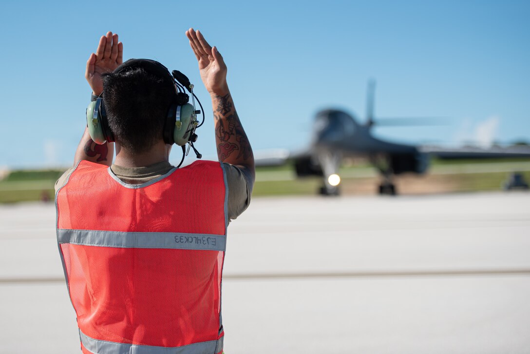 U.S. Air Force Senior Airman Calvin Agabin, 28th Aircraft Maintenance Squadron crew chief assigned to Ellsworth Air Force Base, South Dakota, marshals a B-1B Lancer in support of a Bomber Task Force mission at Andersen AFB, Guam, Nov. 2, 2022.