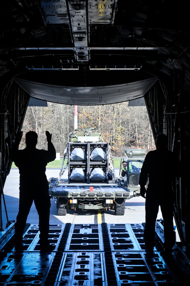 A Polish Air Force loadmaster, and personnel from U.S. Air Forces in Europe-Air Force Africa (USAFE-AF), and U.S. Special Operations Command Europe (SOCEUR), ground guide palletized precision effects cargo onto a Polish Air Force C-130 Hercules, Nov. 8, 2022, in Powidz, Poland. The Rapid Dragon Palletized Effects System, capable of deploying long-range cruise missiles using standard airdrop procedures from a cargo aircraft, was successfully deployed from an MC-130J Commando II on a Norwegian range Nov. 9, 2022.