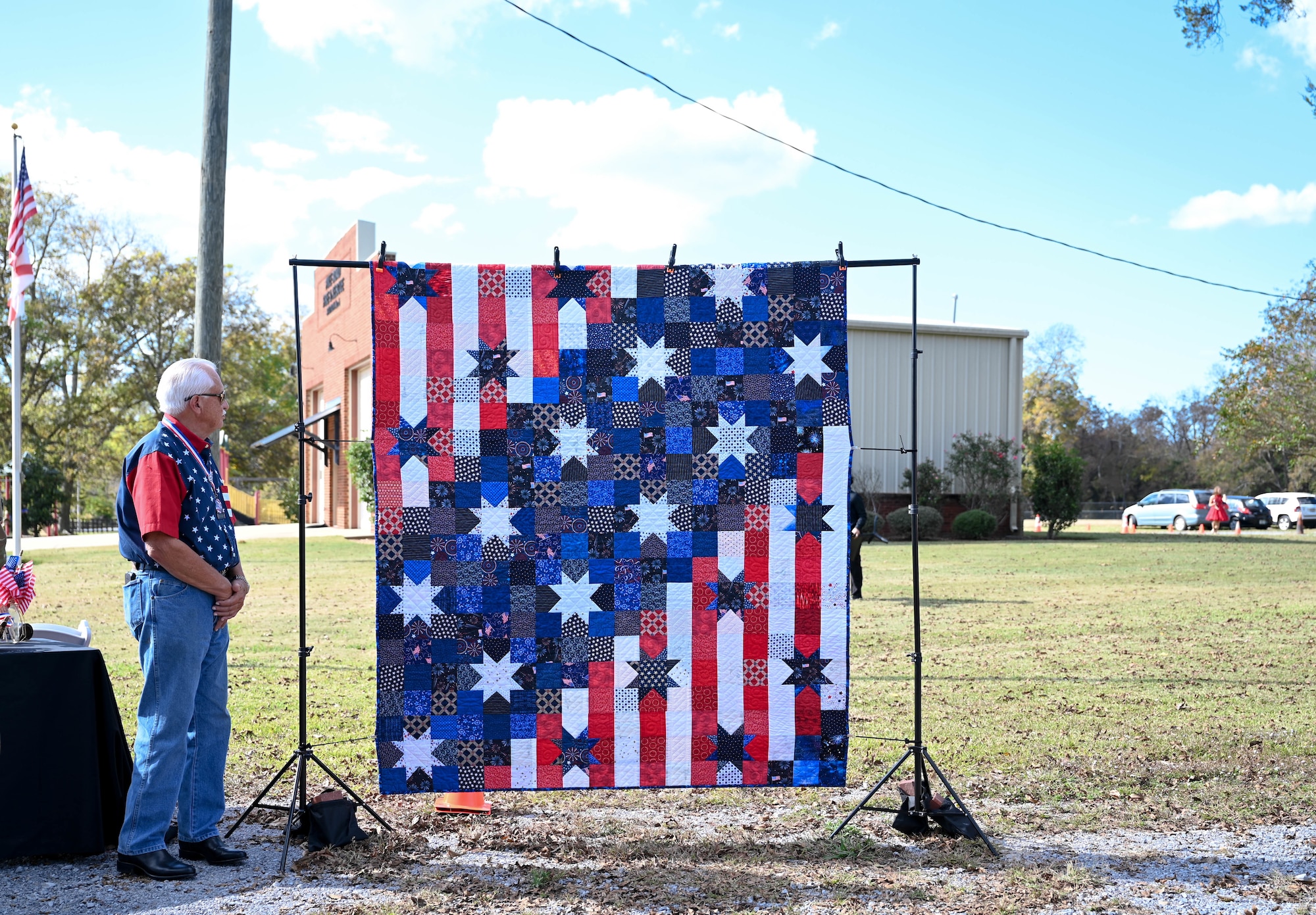 a man looks at a quilt