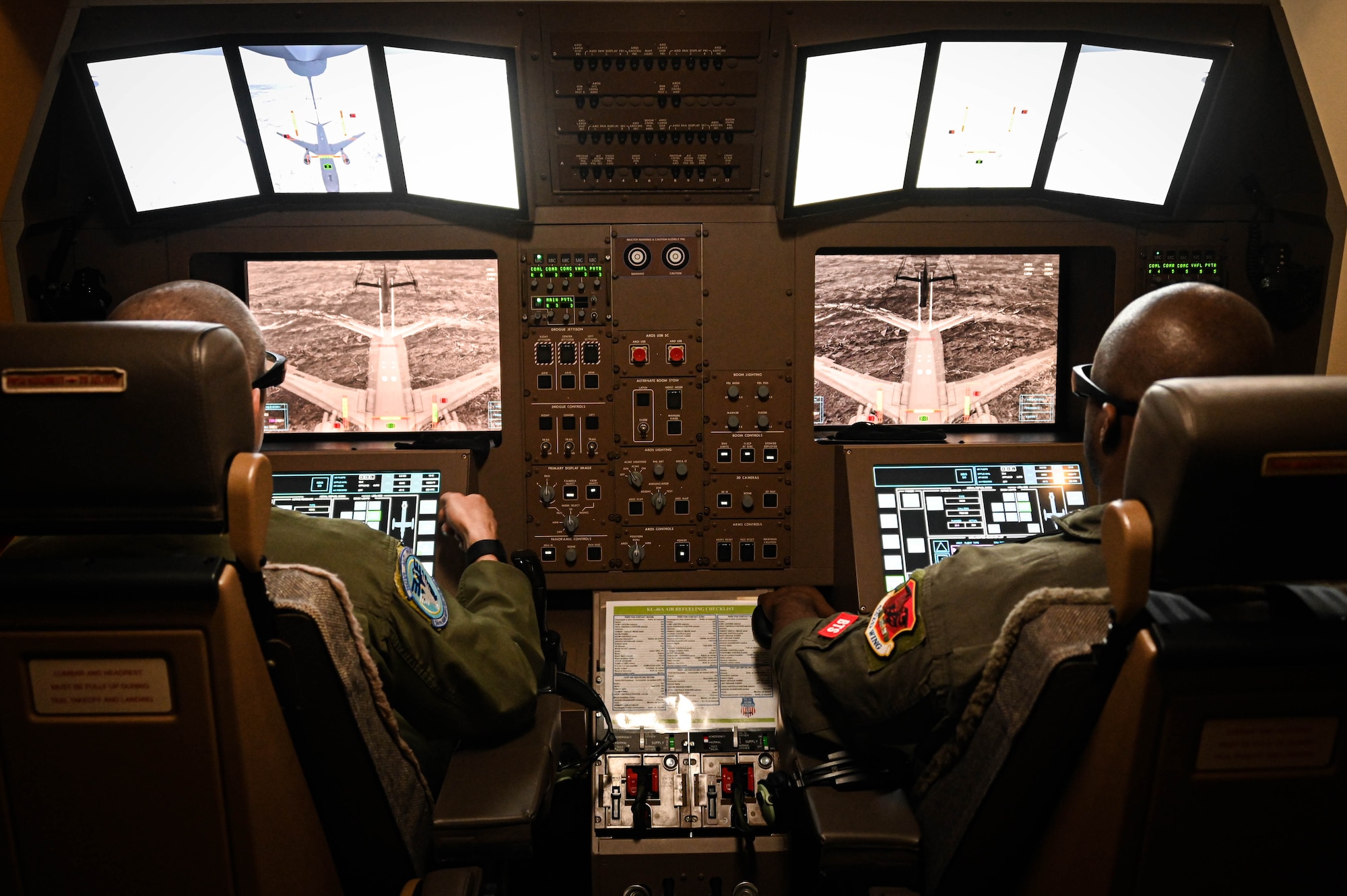 U.S. Air Force Master Sgt. Joseph Vondohlen (left), 54th Air Refueling Squadron boom operator
instructor, and Tech. Sgt. Marcus, 432nd Air Expeditionary Wing evaluator sensor operator, practice in-flight air refueling in a Boom Operator Training (BOT) simulator at Altus Air Force Base, Oklahoma, March 9, 2022. BOT is a new simulation system the 97th Air Mobility Wing uses to train boom operators to refuel from the KC-46 Pegasus. (U.S. Air Force photo by Senior Airman Kayla Christenson)