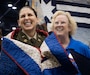 Col. Tina L. Kirkpatrick (left), commander, commander, 475th Quartermaster Group, expresses her gratitude to members of Quilts of Valor during the International Quilting Festival in Houston Nov. 3, 2022. Kirkpatrick was invited to the festival by senior leaders of Quilts of Valor so they could present a custom quilt designed by Leo McClure, one of more than 10,000 Quilts of Valor members. Kirkpatrick, who also serves as the suicide prevention program manager for the 75th Innovation Command, plans to collaborate with Quilts of Valor, a national organization that has made more than 300,000 quilts designed specifically for veterans in honor of their service and sacrifice, to integrate quilting as a form of art therapy to enhance Soldier resiliency. (U.S. Army photo by Staff Sgt. John L. Carkeet IV, 75th Innovation Command).