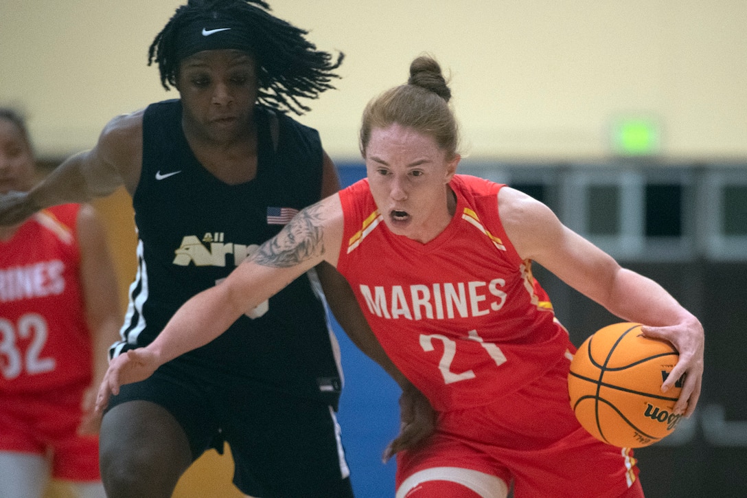 Marine 1st Lt Caitland Considine of MCB Camp Butler Japan drives past Army defender during their first game of the 2022 Armed Forces Women's Basketball Championship aboard Naval Base San Diego, California. (DoD photo by EJ Hersom)