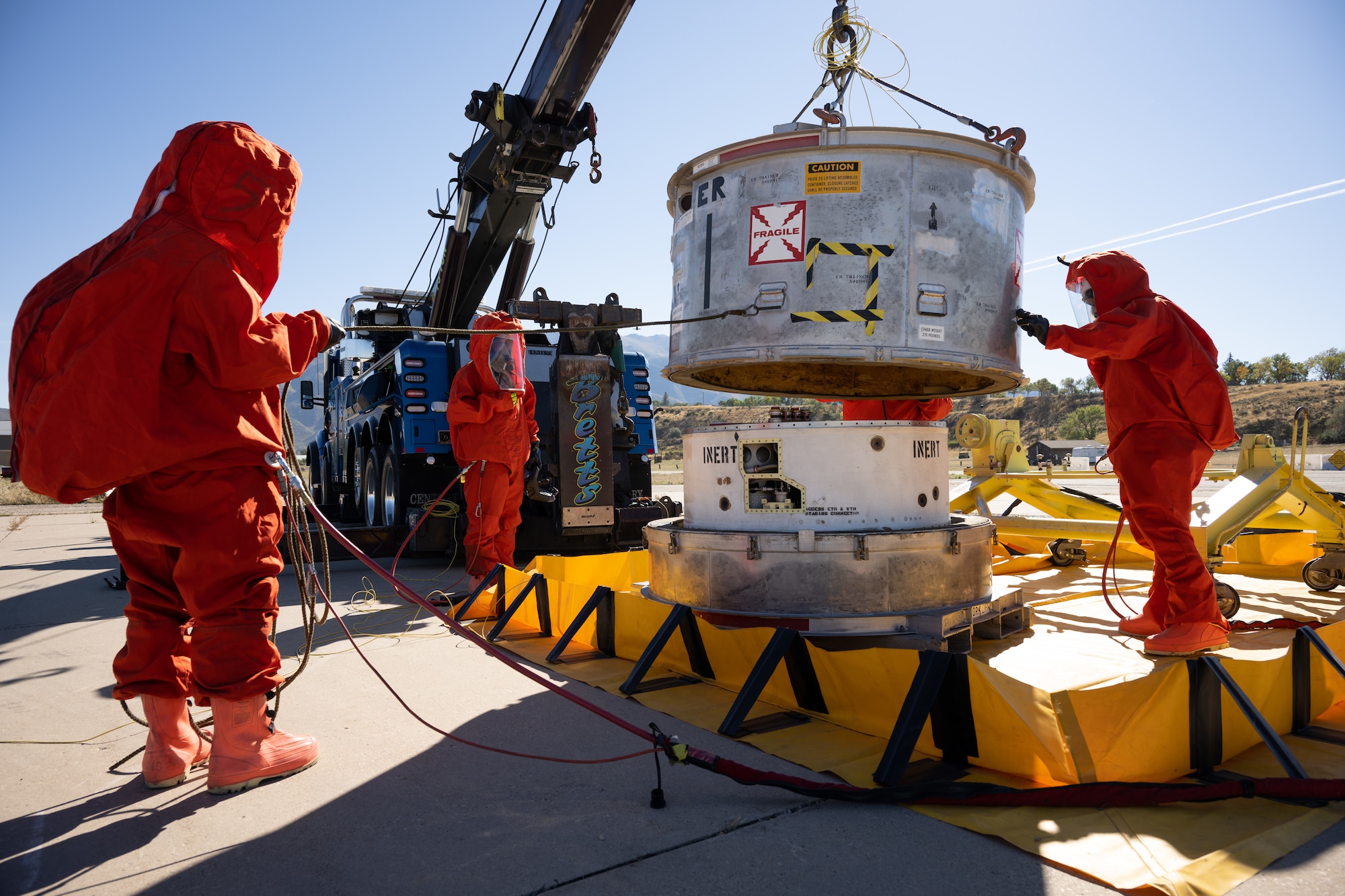 Members of the Missile Mishap Response Team place a container lid over the top of  Minuteman III inert guidance system container during a training event at Hill Air Force Base, Utah, Oct. 4, 2022.
