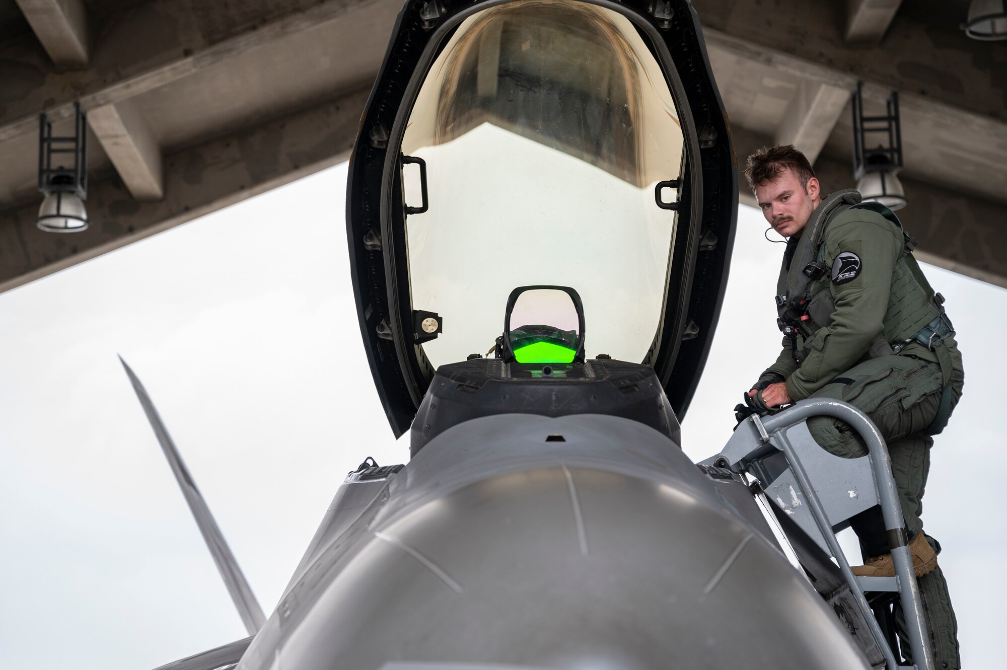 A U.S. Air Force F-22 Raptor pilot assigned to the 525th Fighter Squadron descends from the cockpit after arriving as part of a temporary deployment at Kadena Air Base, Japan, Nov. 8, 2022. The deployment of newer and more advanced aircraft at Kadena exemplifies the Department of Defense's continued commitment to enhancing our posture while building on the strong foundation of our Alliance With Japan. (U.S. Air Force photo by Senior Airman Jessi Roth)