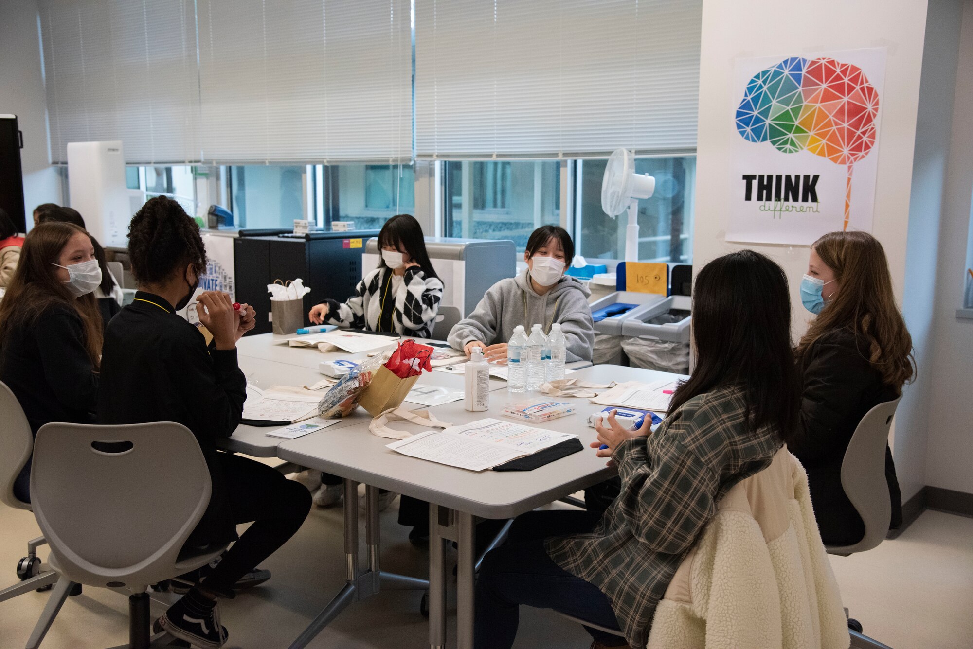 Students sit around their group doing an activity.