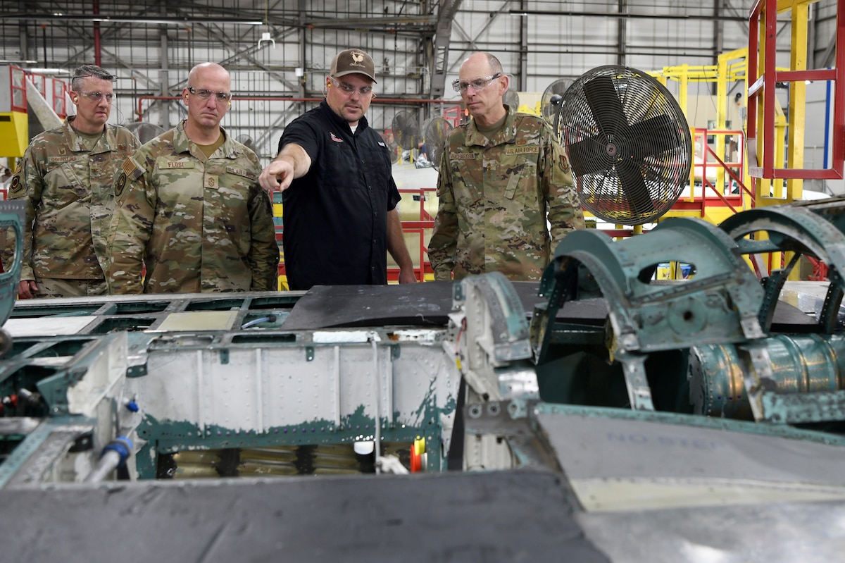 Photo shows group of people looking inside of an aircraft wing