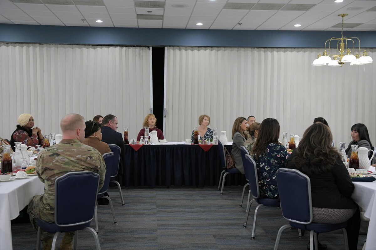 Photo shows people sitting around group of tables