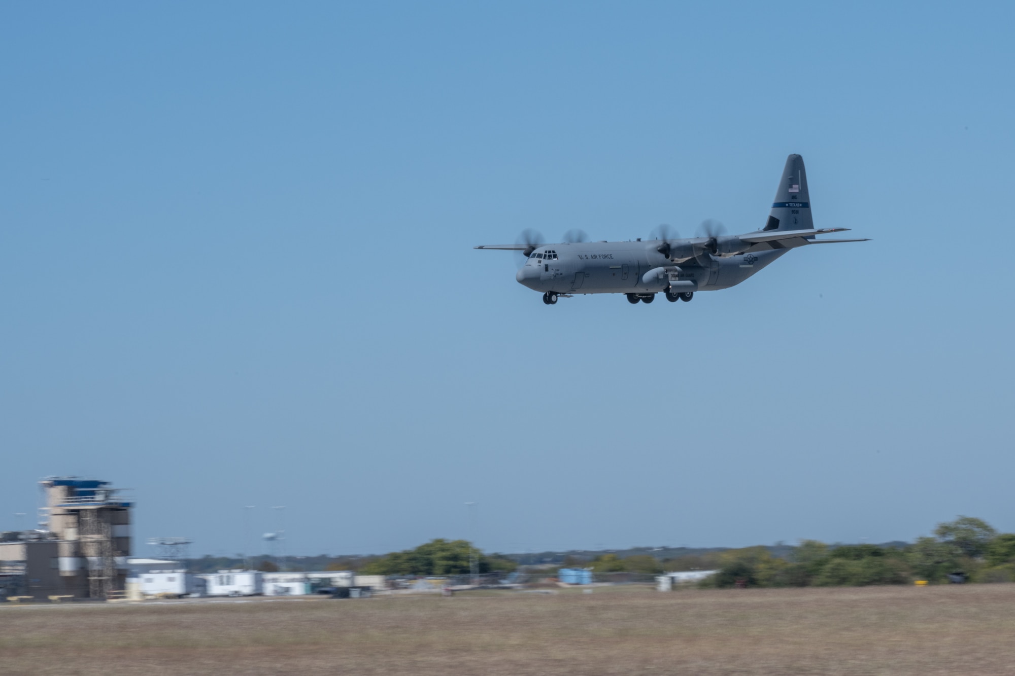 C-130J prepares to land on runway.