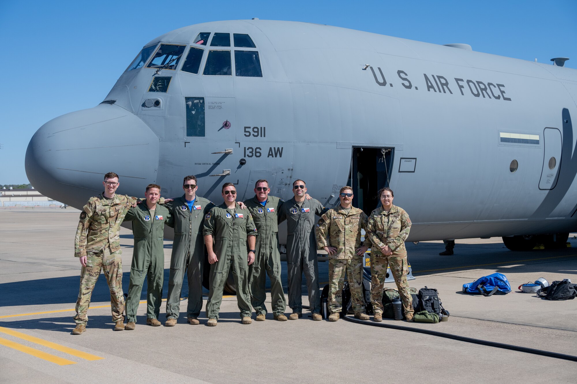 Air crew poses with C-130J on flightline.