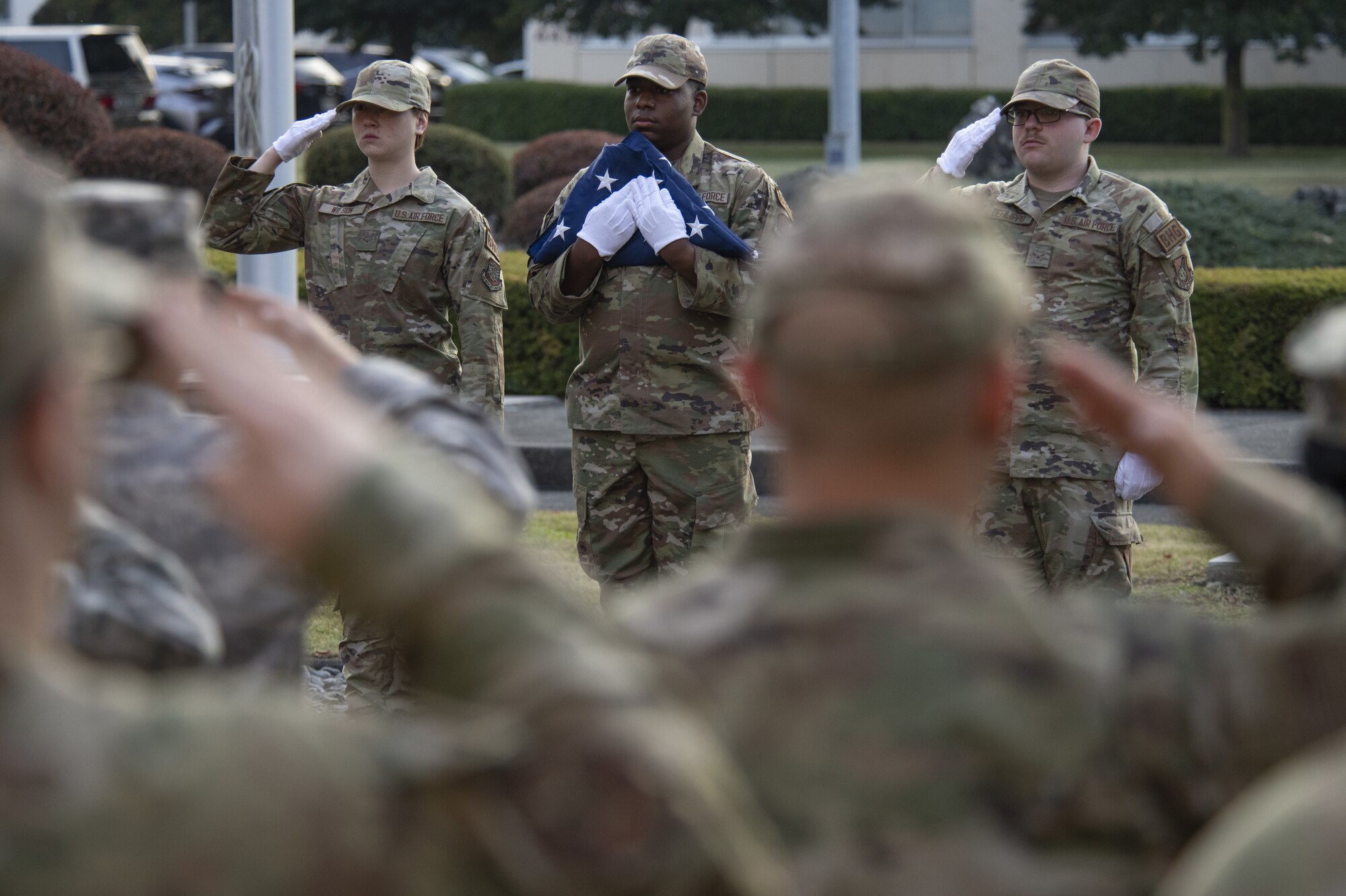 From left to right, Airman 1st Class Elyse Wilson, Airman 1st Class Jatravious Ingram, and Airman 1st Class Pierce DeFilippo, Yokota Air Base honor guard members, participate in a retreat ceremony as part of the 2022 Yokota Veterans Day Ceremony at Yokota Air Base, Japan, Nov. 10, 2022. Members of Yokota conducted the ceremony as a way to respect and recognize the contributions veterans and their families have made toward freedom and peace across the globe. (U.S. Air Force photo by Tech. Sgt. Christopher Hubenthal)