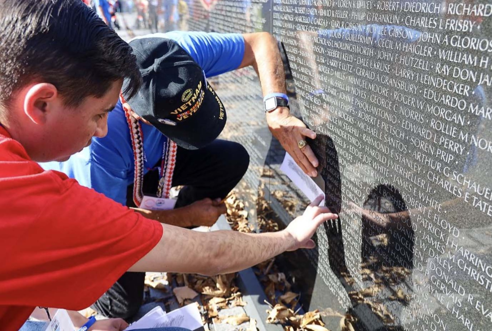 Arroyo and Martinez create a rubbing of a service member's name while visiting the Vietnam Veterans Memorial, Nov. 5, in Washington.