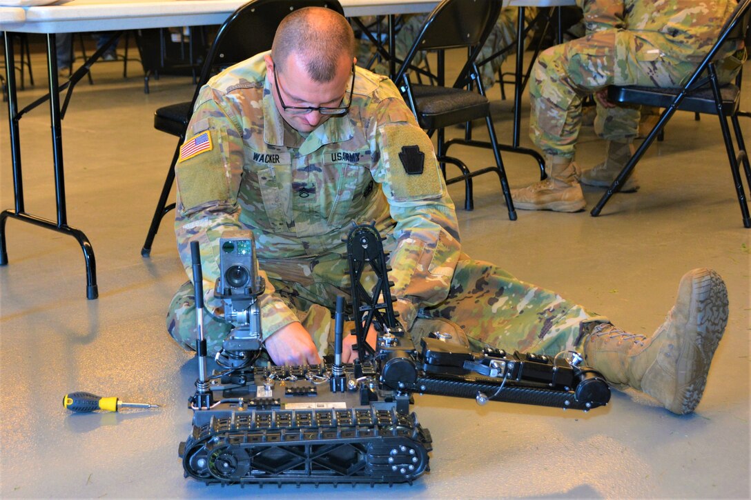 Staff Sgt. Matthew Wacker of Headquarters and Headquarters Company, 876th Brigade Engineer Battalion, 2nd Infantry Brigade Combat Team disassembles a Common Robotic System – Individual during training on Nov. 9, 2022, at Fort Indiantown Gap, Pa. The CRS-I is a 32-pound, tracked robot with multiple cameras and an extendable arm that can fit into a medium ruck sack or an assault pack.