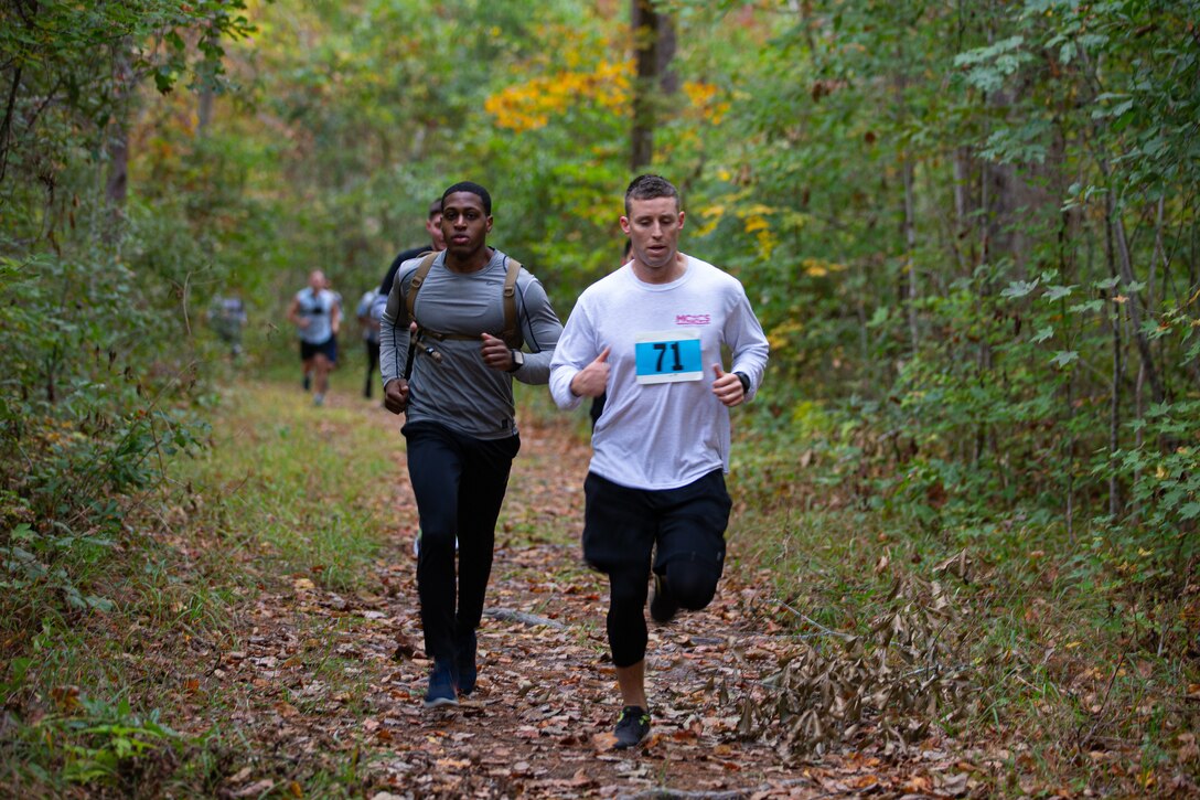 U.S. Marines assigned to Marine Corps Air Station (MCAS) Cherry Point run to the next challenge on a bike path at Devil Dog Dare during the 25th Annual All-Terrain Unit Competition, MCAS Cherry Point, North Carolina, Oct. 28, 2022. Participants had to complete five physically demanding challenges over a seven-mile course. The competition allowed various units to build comradery while boosting morale. (U.S. Marine Corps photo by Cpl. Symira Bostic)