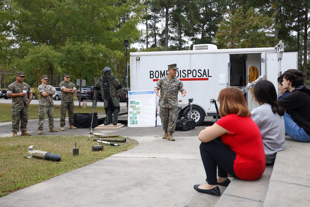 U.S. Marine Corps Master Sgt. Carlos Villarreal, an explosive ordnance disposal (EOD) technician with Headquarters and Headquarters Squadron (H&HS), Marine Corps Air Station (MCAS) Cherry Point, teaches students at Tucker Creek Middle School about EOD during its annual career day, Havelock, North Carolina, Oct. 24, 2022. EOD attended the career fair in conjunction with H&HS, MCAS Cherry Point and Tucker Creek Middle School’s Adopt-A-School partnership, a program providing students with positive role models and teachers with additional resources. (U.S. Marine Corps photo by Cpl. Symira Bostic)