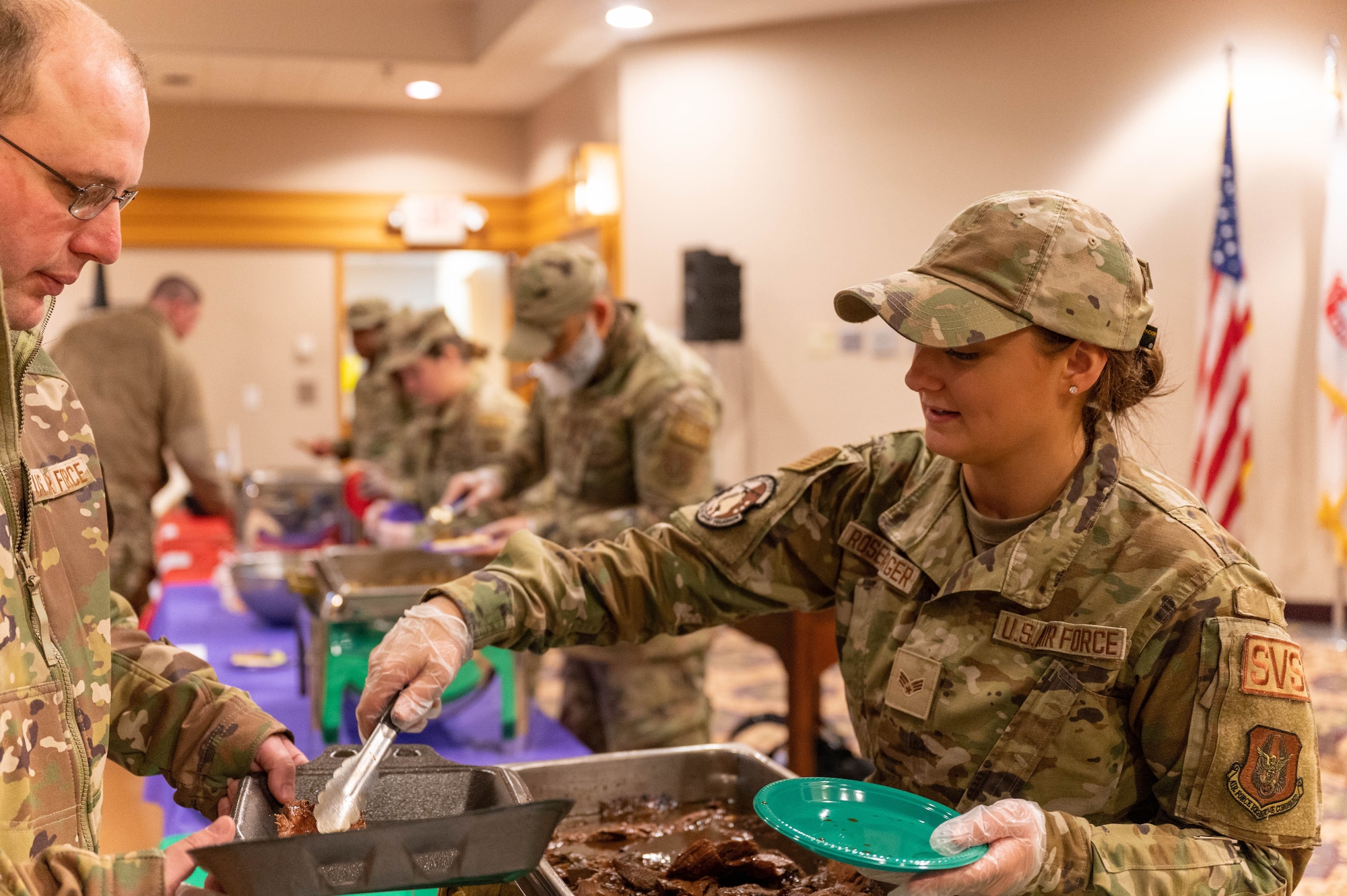 Senior Airman Samantha Rosenberger, 934th Force Support Squadron services specialist, serves flank steak during the 934th Airlift Wing’s first Celebration of Nations event at Minneapolis-Saint Paul Air Reserve Station, Minnesota, Nov. 5, 2022. This event provided Airmen an opportunity to try culturally different foods, listen to different music and look at different types of clothes. (U.S. Air Force photo by Airman First Class Colten Tessness)