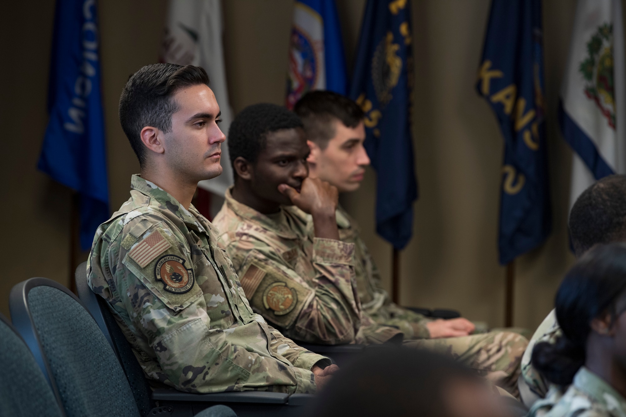 A photo of an Airman sitting in a crowd