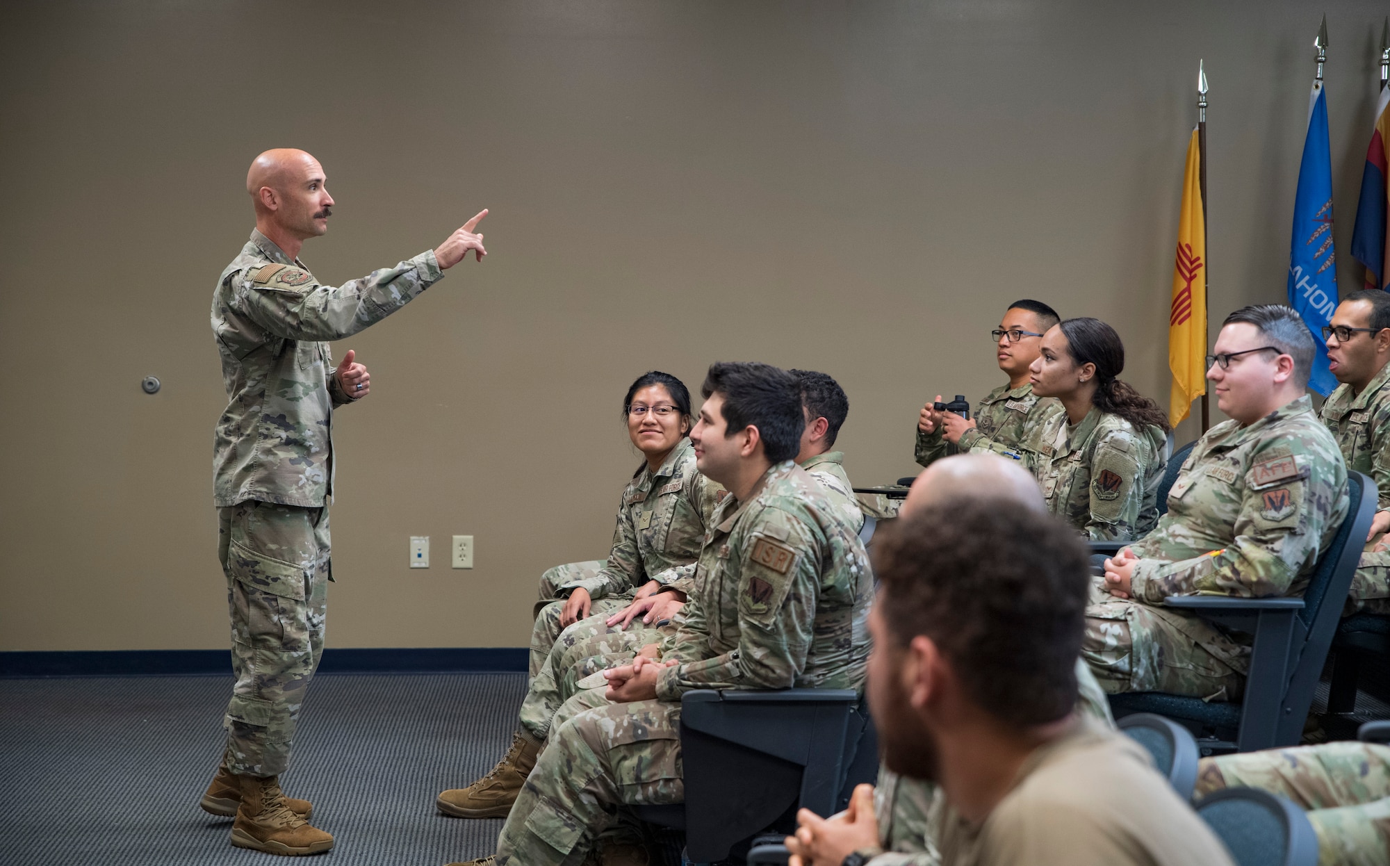 A photo of an Airman talking to a group of airmen.