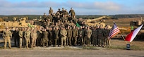U.S. Army Soldiers assigned to 3rd Armored Brigade Combat Team, 1st Calvary Division and Polish soldiers assigned to the 11th Armored Lubuska Cavalry Division takes a group photo at Abrams Logistical Summit at DPTA, Poland Oct. 26 2022. The 3-4 ABCT is among other units assigned to the 1st Infantry Division, proudly working alongside NATO allies and regional security partners to provide combat-credible forces to V Corps, America's forward deployed corps in Europe. (U.S. Army National Guard photo by Sgt. Andrew Greenwood.)