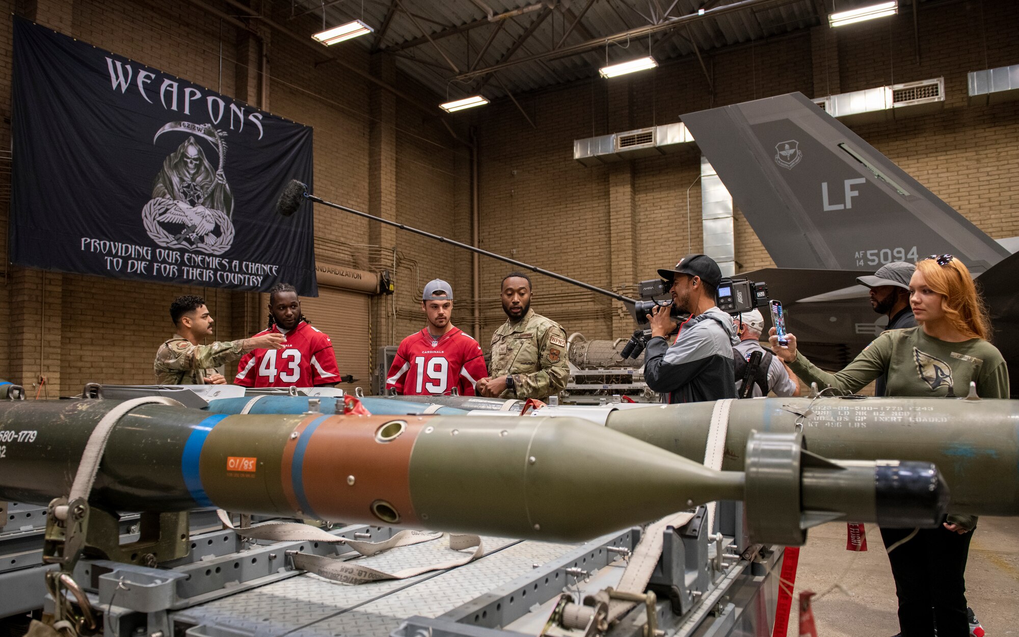 Airmen of the 56th Component Maintenance Squadron speak to Arizona Cardinals players Jesse Luketa and Trace McSorley about F-35 Lightning II weapon delivery systems Nov. 1, 2022, during a tour of Luke Air Force Base, Arizona.