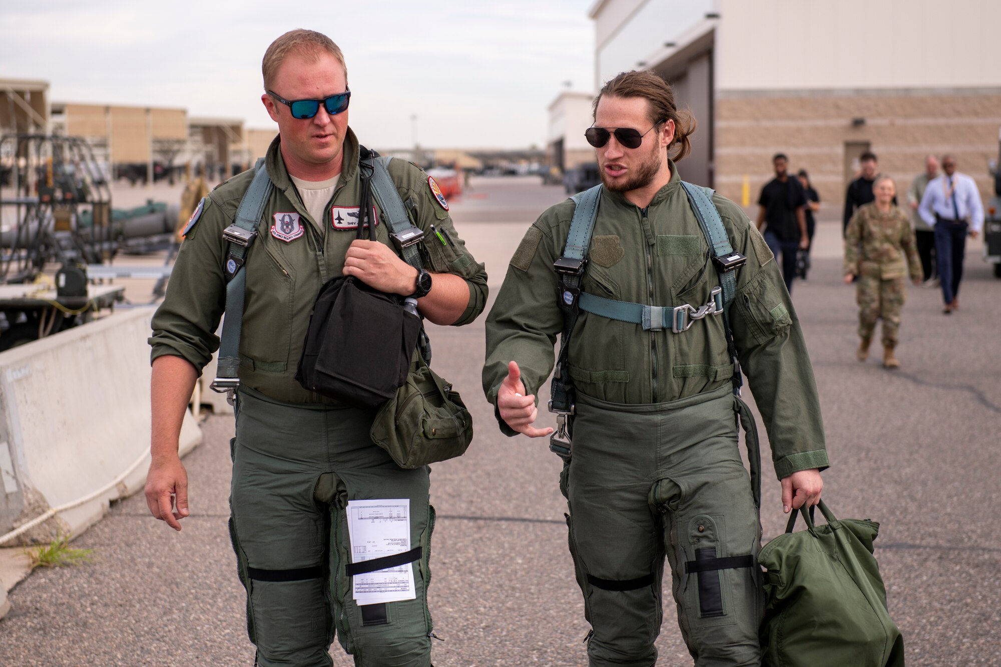 U.S. Air Force Maj. Aaron Johnson, 69th Fighter Squadron F-16 instructor pilot, and Dennis Gardeck, Arizona Cardinals offensive linebacker, walk to the flightline Nov. 1, 2022, at Luke Air Force Base, Arizona.