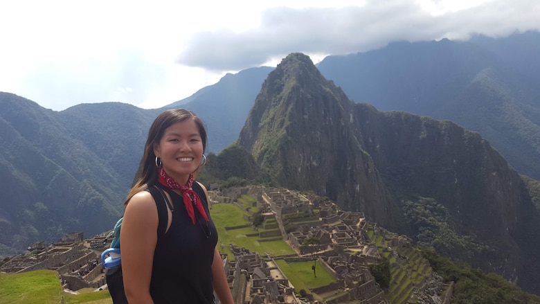 Photo of Connie Chow standing on a hill with the Machu Pichu site in the background.