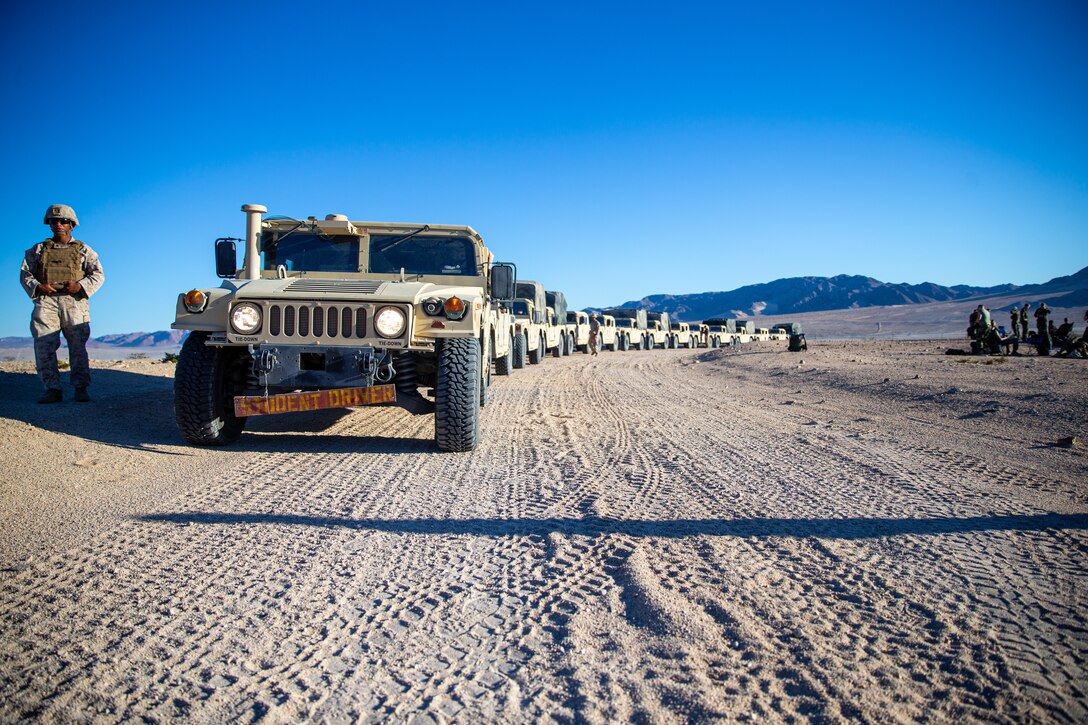 A line up of tactical vehicles on a dirt road