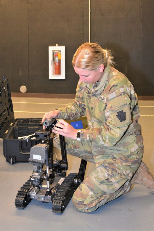 Sgt. Maecy Rademacher of Alpha Company, 876th Brigade Engineer Battalion, 2nd Infantry Brigade Combat Team attaches a camera a Common Robotic System – Individual during training on Nov. 9, 2022, at Fort Indiantown Gap, Pa. The CRS-I is a 32-pound, tracked robot with multiple cameras and an extendable arm that can fit into a medium ruck sack or an assault pack.
