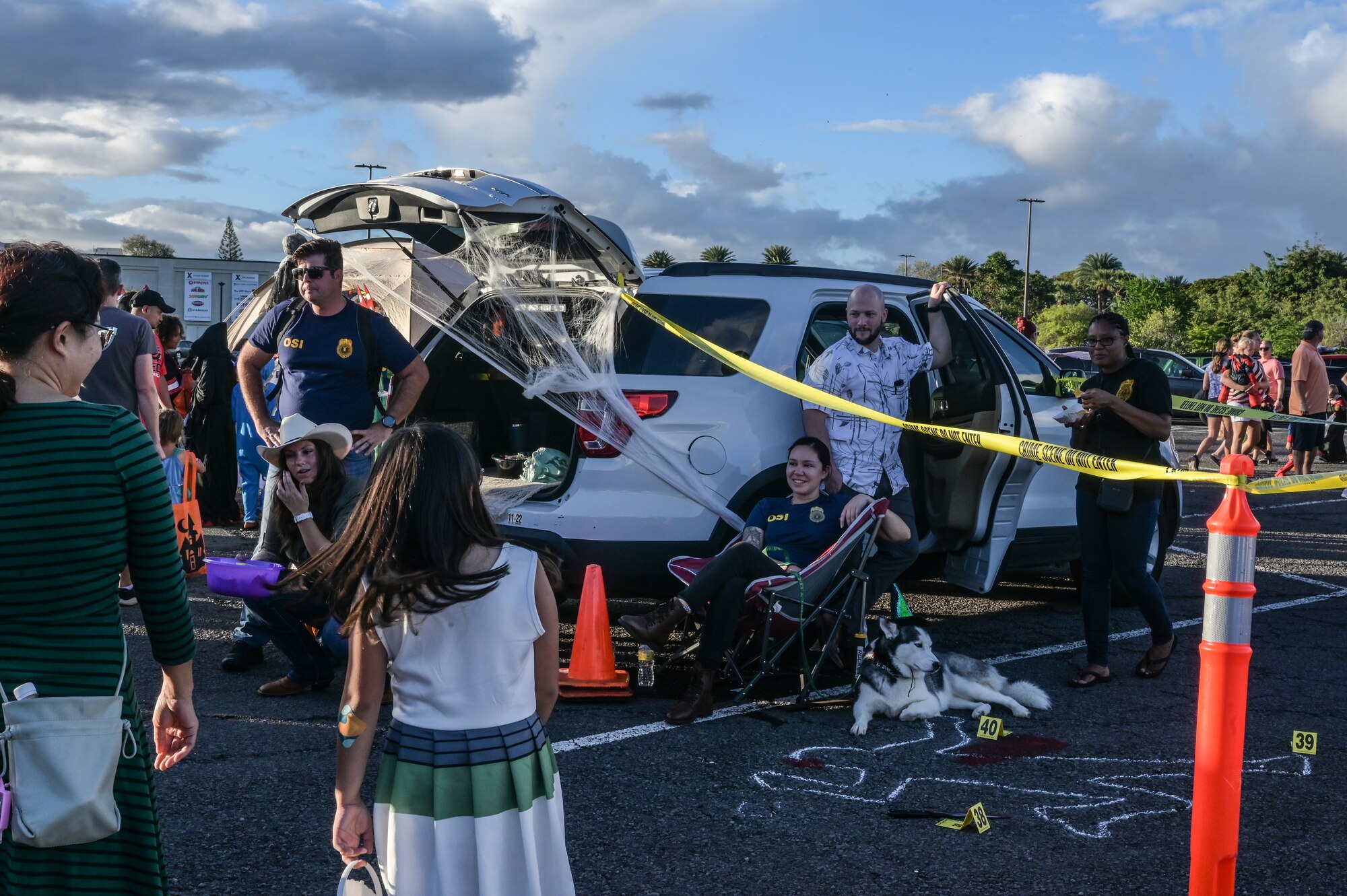 Members assigned to the Air Force Office of Special Investigations, Detachment 601, pass out Halloween candy during the Trunks of Treats event at Joint Base Pearl Harbor-Hickam, Hawaii, Oct. 28, 2022. Trunk-or-Treat is an event that offers trick-or-treating down a row of decorated vehicles for families to walk through and receive candy. (U.S. Air Force photo by Staff Sgt. Alan Ricker)