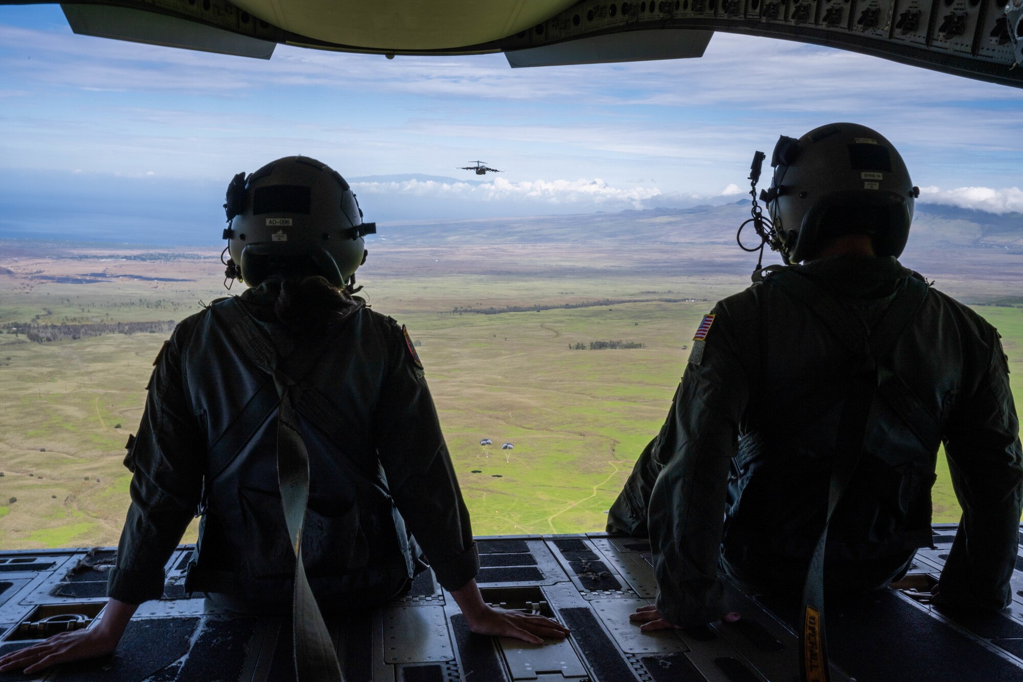 U.S. Air Force 1st Lt. Cassidy Mullen, 535th Airlift Squadron pilot, and Tech. Sgt. John Pate, 15th Aircraft Maintenance Squadron flying crew chief, sit on the ramp of a C-17 Globemaster III during an aerial maneuver training flight as part of Joint Pacific Multinational Readiness Center (JPMRC) exercise 23-01, Nov. 5, 2022. The bilateral exercise helps strengthen relationships and increases interoperability to help ensure a free and open Indo-Pacific. (U.S. Air Force photo by Senior Airman Makensie Cooper)
