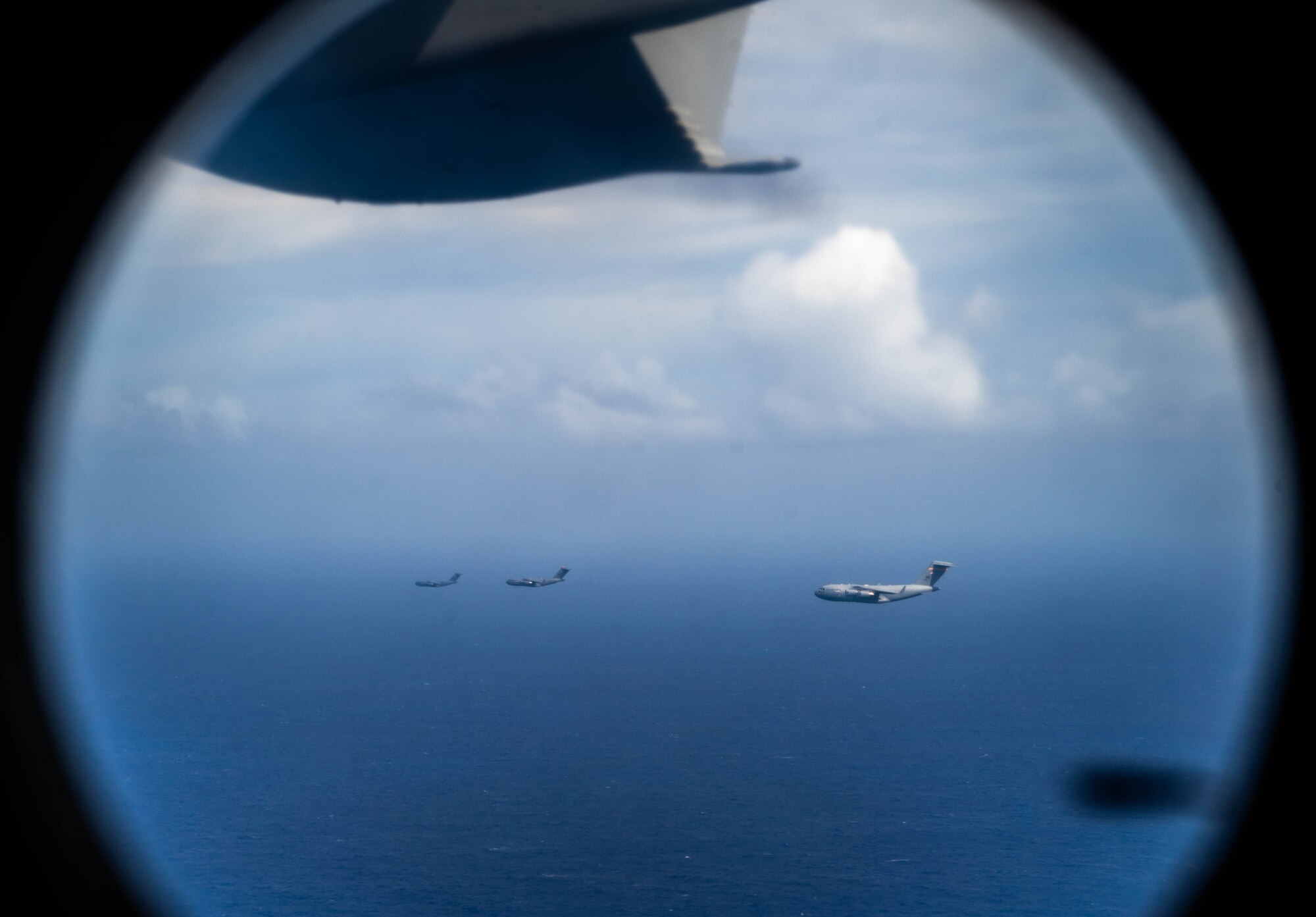 Three U.S. Air Force C-17 Globemaster III fly in formation in support of Joint Pacific Multinational Readiness Center (JPMRC) exercise 23-01, Nov. 5, 2022. This exercise builds combat readiness and strengthens relationships across the Pacific theater. (U.S. Air Force photo by Senior Airman Makensie Cooper)