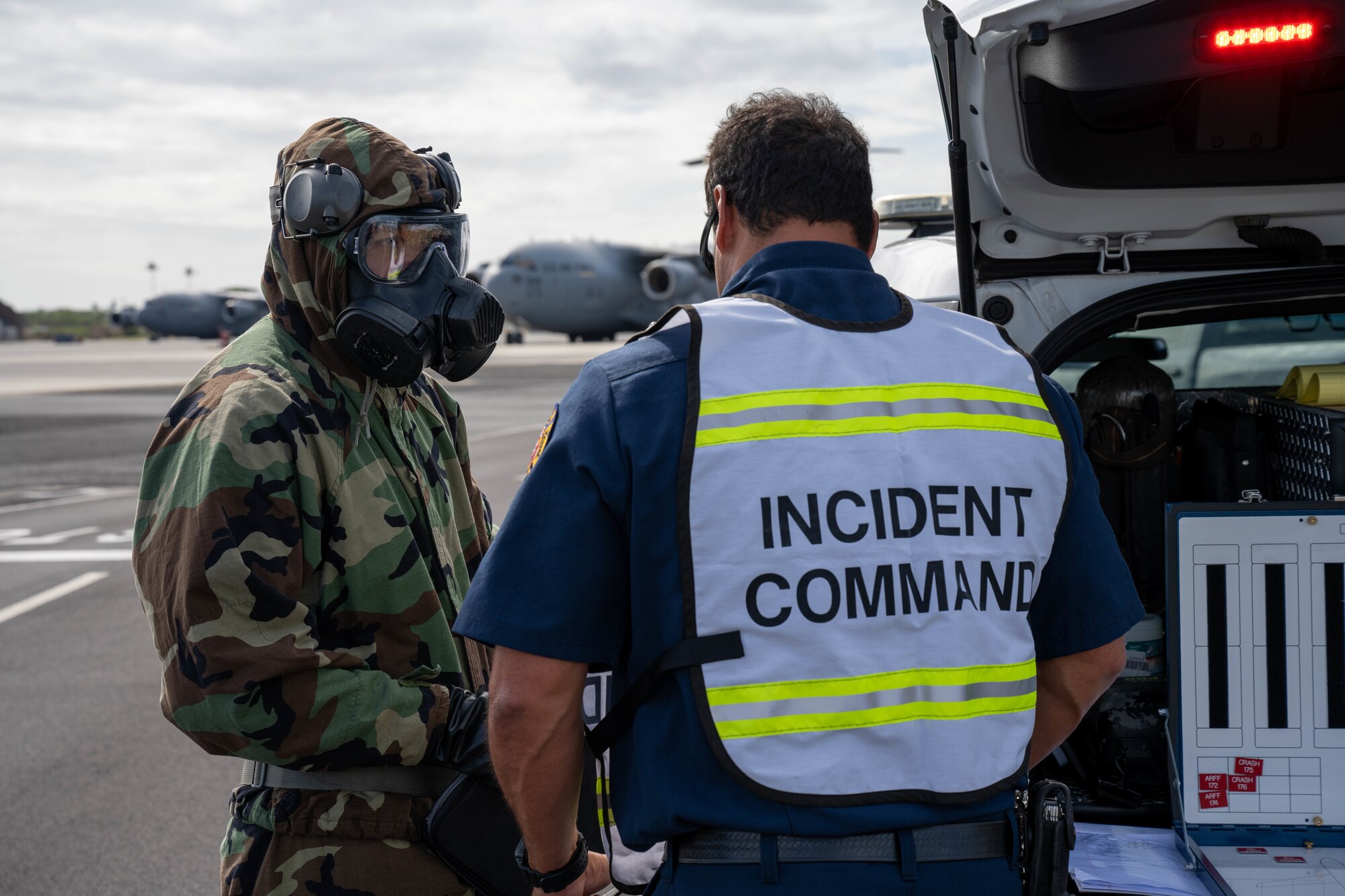 Master Sgt. Dominic Santos, 15th Aircraft Maintenance Squadron production superintendent, speaks with the on-scene incident commander during the decontamination exercise at Joint Base Pearl Harbor-Hickam, Hawaii, Nov. 9, 2022. Hickam Airmen participated in different training exercises, including marshaling an aircraft, decontaminating aircaft and cargo, treating aircrew and emergency procedures in order to maintain mission readiness. (U.S. Air Force photo by Senior Airman Makensie Cooper)