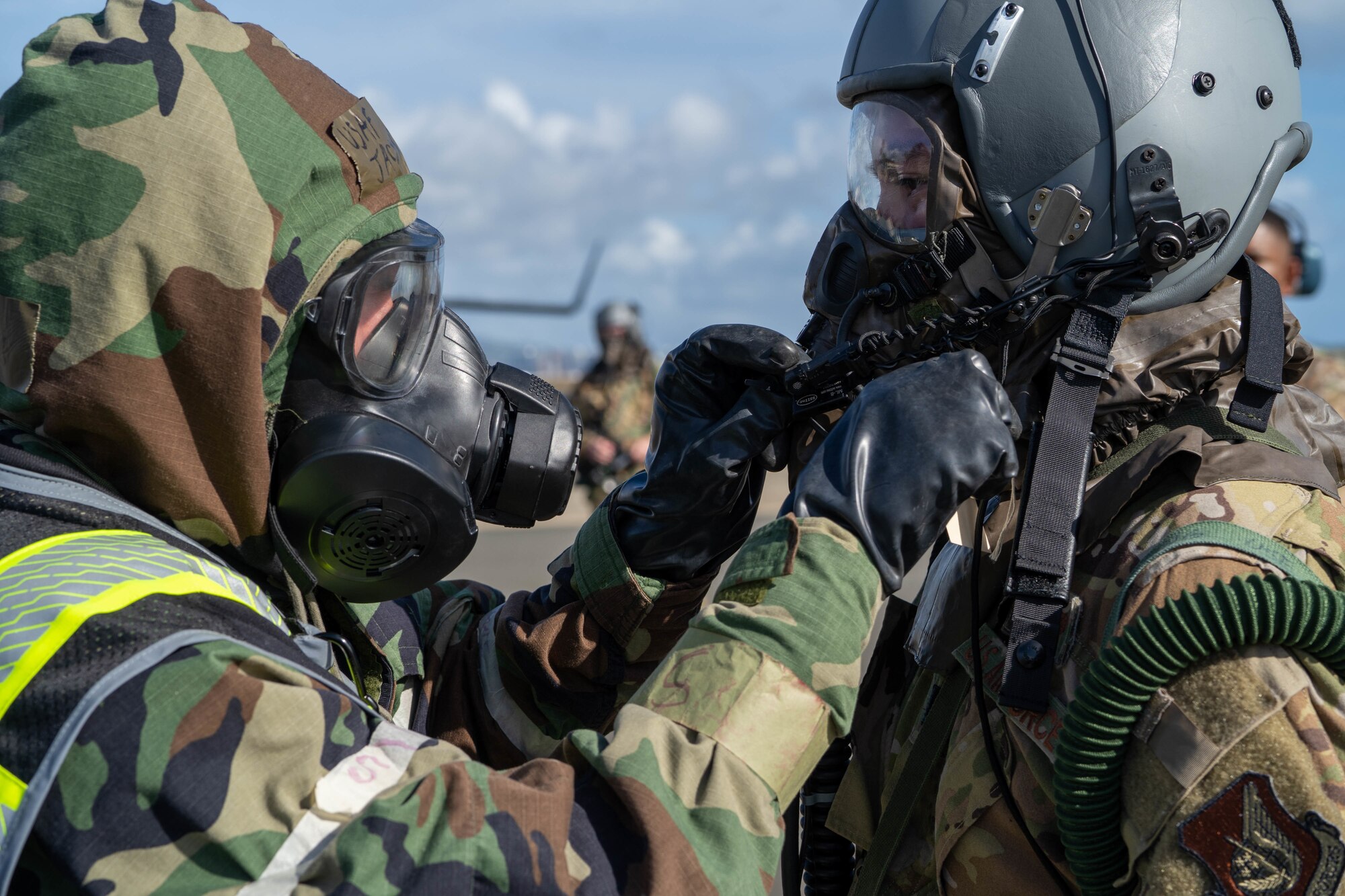 Airman 1st Class Jacyn Revels, 15th Operations Support Squadron aircrew flight equipment journeyman, inspects the mask of 1st Lt. Erik Braunstein, 535th Airlift Squadron pilot, during a decontamination exercise at Joint Base Pearl Harbor-Hickam, Hawaii, Nov. 9, 2022. Hickam Airmen demonstrated how to treat aircrew as well as decontaminate an aircraft and cargo that has been exposed to a chemical or biological agent to maintain operational readiness. (U.S. Air Force photo by Senior Airman Makensie Cooper)