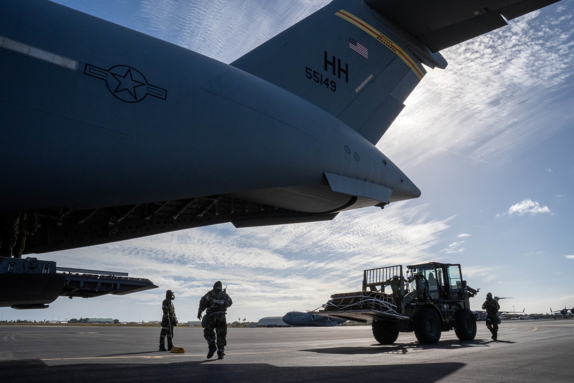Airmen assigned to the 735th Air Mobility Squadron unload cargo from a C-17 Globemaster III during a decontamination exercise at Joint Base Pearl Harbor-Hickam, Hawaii, Nov. 9, 2022. Hickam Airmen trained  how to decontaminate an aircraft, aircrew and cargo that has been exposed to a chemical or biological agent to maintain operational readiness. (U.S. Air Force photo by Senior Airman Makensie Cooper)