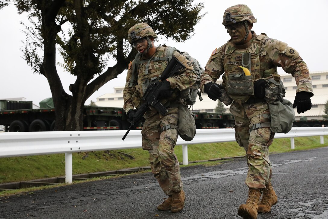 Pfc. Matthew Hicks, left, and his sponsor, Sgt. Jonathan Benavente, both assigned to the 35th Combat Sustainment Support Battalion, finish a ruck march event together during the unit’s second annual “Best Warrior” competition Oct. 14 on Sagami General Depot, Japan.