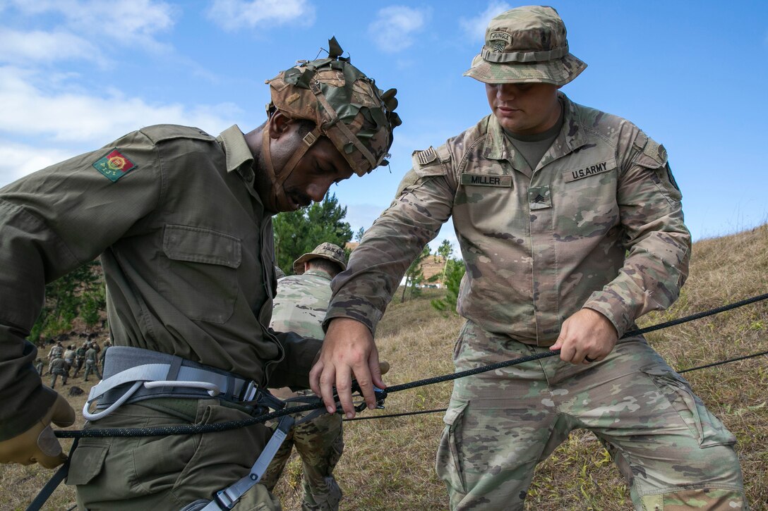 U.S. Army Sgt. Jacob Miller, an infantryman with Bravo Company, 2nd Battalion, 27th Infantry Regiment, 3rd Infantry Brigade Combat Team, 25th Infantry Division, shows a Soldier with the Republic of Fiji Military Force how to tie in during rappel instruction in the highlands during Exercise Cartwheel, Nadi, Fiji, September 18, 2022. Bilateral military-to-military training with the RFMF builds expeditionary readiness and interoperability by increasing the capacity to face crises and contingencies by developing and stressing units at the highest training levels.
