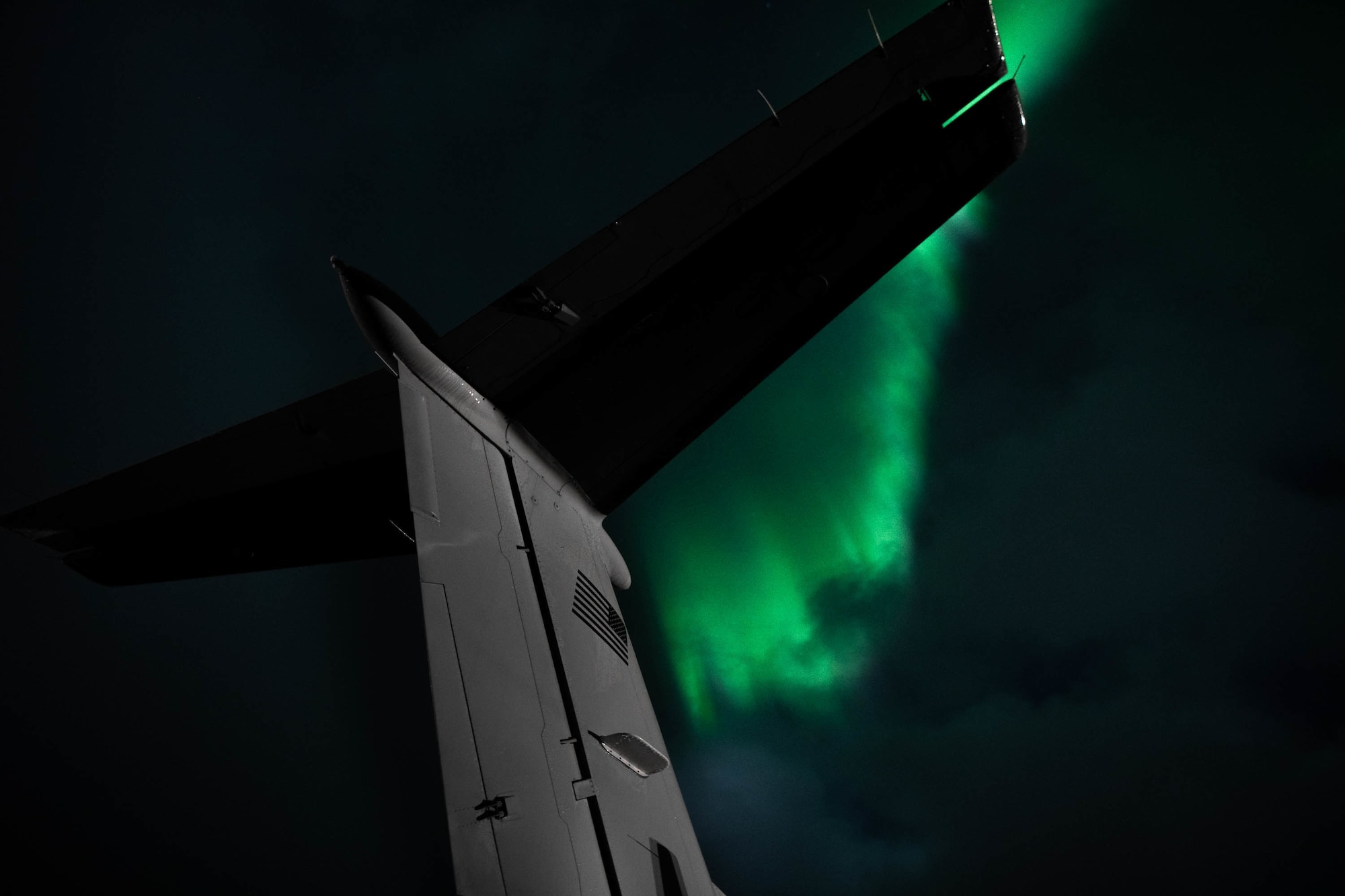 The tail of a 137th Special Operations Wing MC-12W appears struck by the Aurora Borealis while participating in ATREUS 22-4 at Andøya Space Defense Range, Norway, Nov. 7, 2022. Two Air Force Special Operations Command wings partnered in a total force initiative to conduct the first live-fire demonstration of Rapid Dragon, a long-range palletized munitions system. (U.S. Air National Guard photo by Tech. Sgt. Brigette Waltermire)