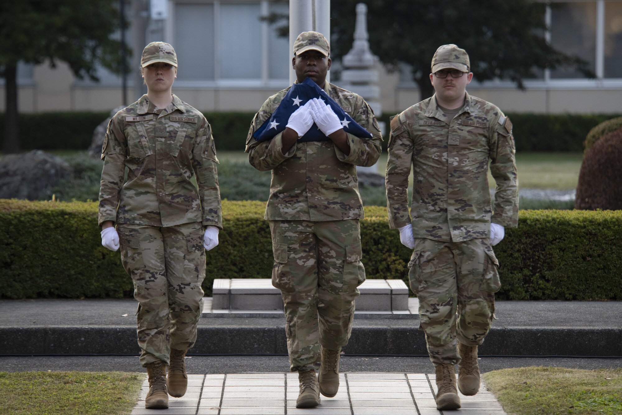 From left to right, Airman 1st Class Elyse Wilson, Airman 1st Class Jatravious Ingram, and Airman 1st Class Pierce DeFilippo, all Yokota Air Base honor guard members, participate in a Retreat ceremony as part of the 2022 Yokota Veterans Day Ceremony at Yokota Air Base, Japan, Nov. 10, 2022. Members of Yokota conducted the ceremony as a way to respect and recognize the contributions veterans and their families, caregivers, and survivors have made toward the cause of freedom and peace across the globe. (U.S. Air Force photo by Tech. Sgt. Christopher Hubenthal)