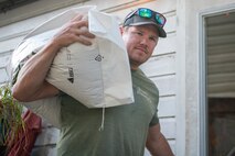 Man carries large bag over shoulder.
