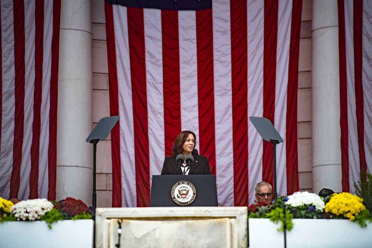 A woman stands behind a lectern.