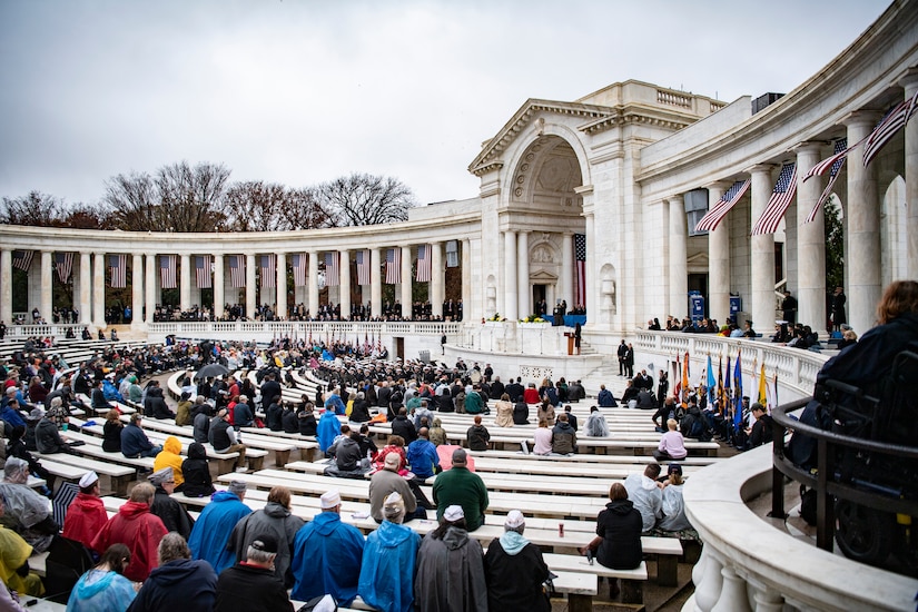 Hundreds of people are seated in a large, outdoor amphitheater.