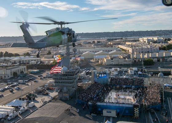An MH-60S Sea Hawk helicopter flies over USS Abraham Lincoln (CVN 72) during the Armed Forces Classic, Carrier Edition 2022.
