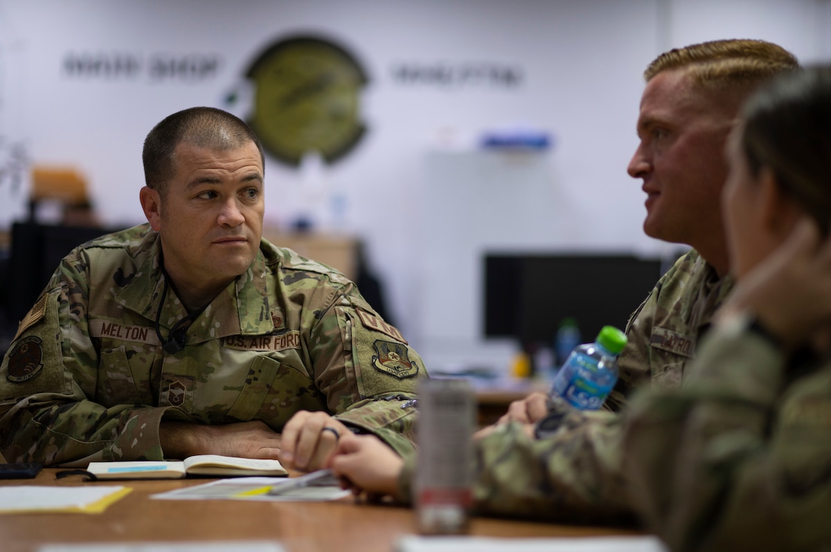 From left, U.S. Air Force Senior Master Sgt. Christopher Melton, 386th Expeditionary Logistics Readiness Squadron vehicle management flight chief, holds a meeting with his team at Ali Al Salem Air Base, Kuwait, Nov. 10, 2022. Melton worked alongside his non-commissioned officers to hash out a plan together and recalibrate their goals to what they wanted to achieve for their shops and for their Airmen. (U.S. Air Force photo by Staff Sgt. Dalton Williams)