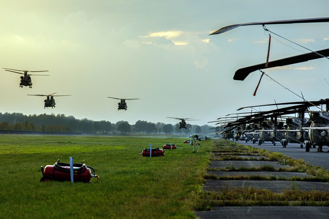 Four helicopters prepare to land.