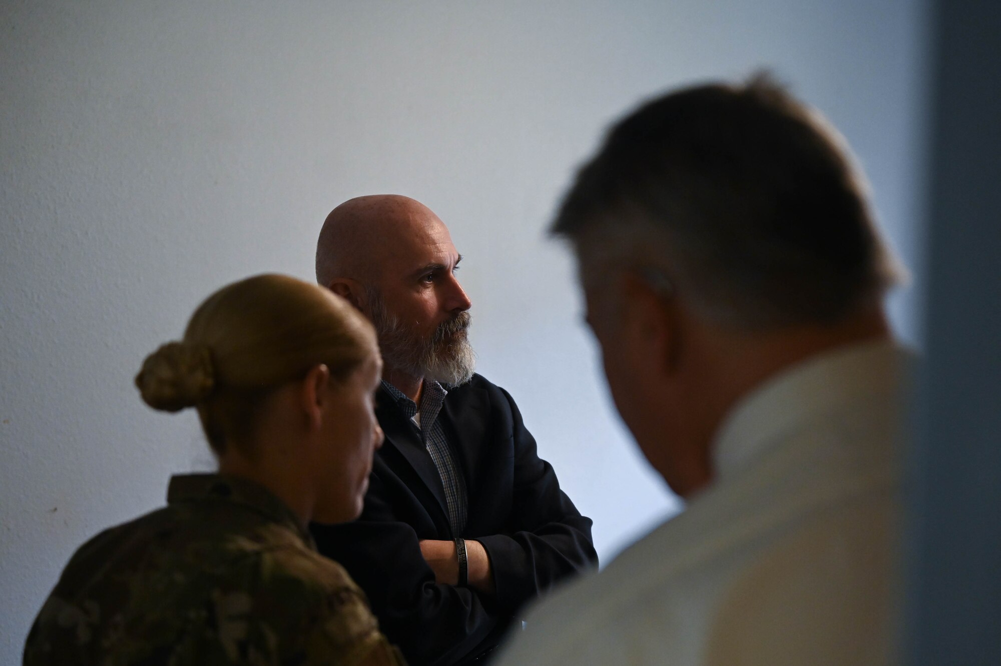A man talks to a group of people in a dorm room.