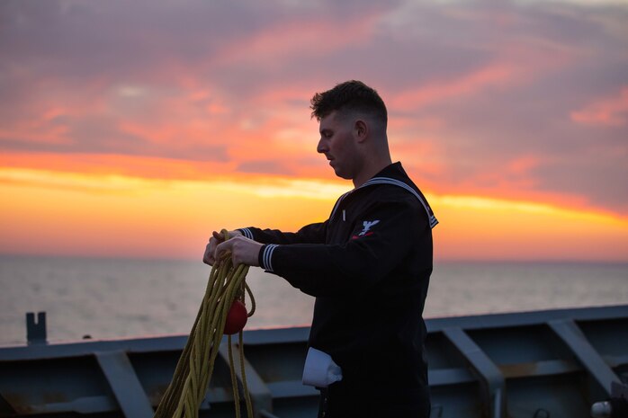 Boatswain’s Mate 3rd Class Shawn Stillson untangles a heaving line on the Ticonderoga-class guided-missile cruiser USS Normandy (CG 60) as the ship pulls into its namesake region in France while underway as part of the Gerald R. Ford Carrier Strike Group, Nov. 14, 2022. The first-in-class aircraft carrier USS Gerald R. Ford (CVN 78) is on its inaugural deployment conducting training and operations alongside NATO Allies and partners to enhance integration for future operations and demonstrate the U.S. Navy’s commitment to a peaceful, stable and conflict-free Atlantic region. (U.S. Navy photo by Mass Communication Specialist 2nd Class Malachi Lakey)