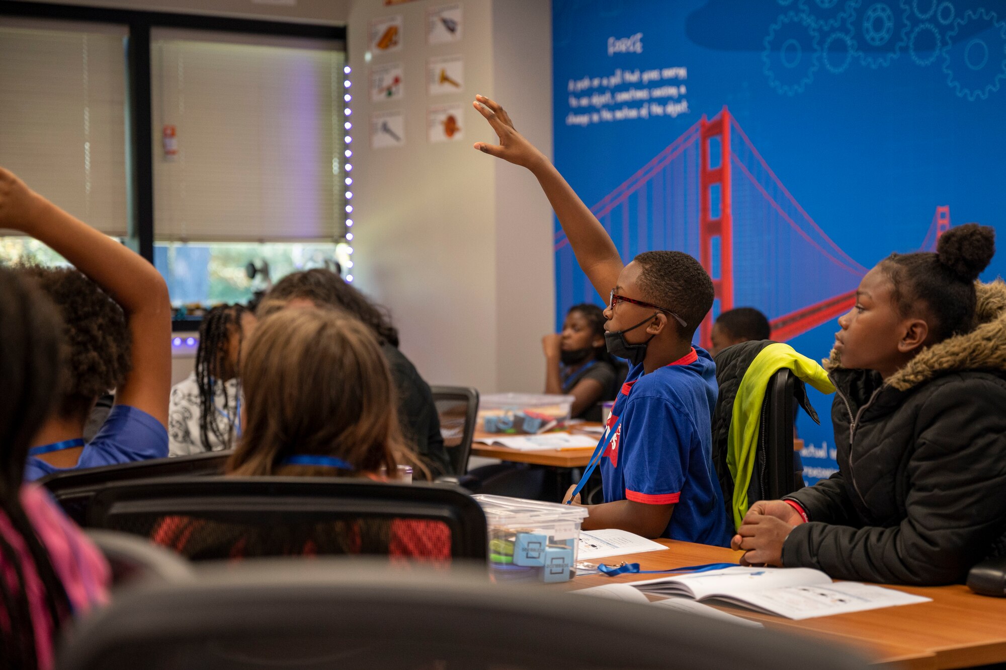 Students raise their hands during a class