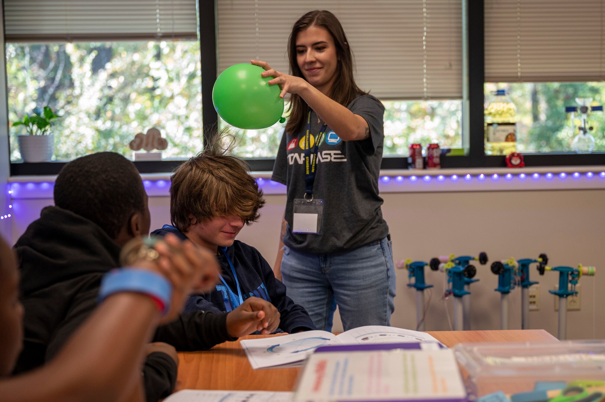 An instructor demonstrates static electricity to her students by using a balloon