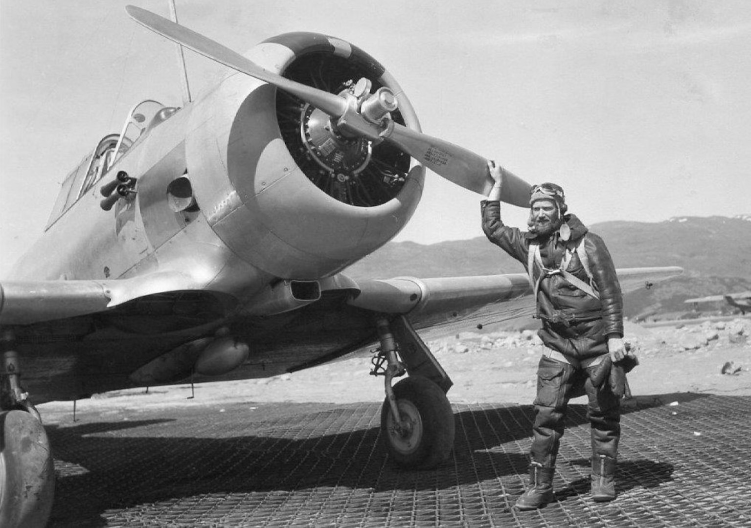 Radioman First Class Benjamin Bottoms in flight gear posed in front of a military trainer aircraft. (Family of Olga Bottoms Richardson)